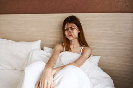 beautiful woman in bed under the covers stretching morning design interior modelの写真素材
