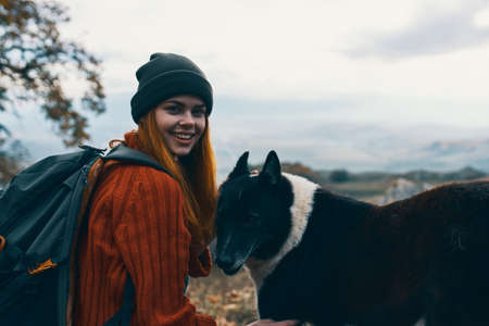 woman hiker in nature petting dog friendship funの写真素材