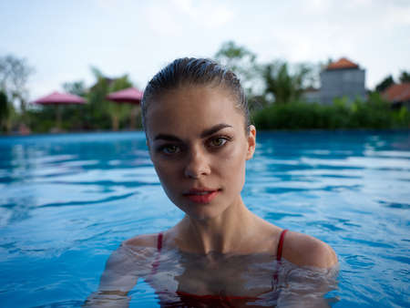 pretty woman in red swimsuit in the pool nature close-up
