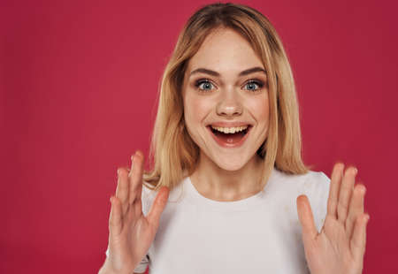 Enthusiastic woman on a red background gestures with her hands joy emotion modelの写真素材