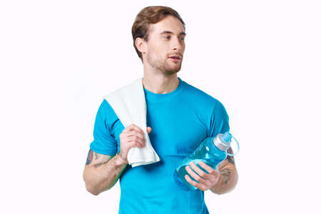 man in blue t-shirt holding bottle fitness cropped viewの写真素材