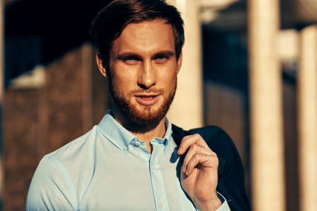 business man in shirt and jacket on the street near the building portrait close-upの写真素材