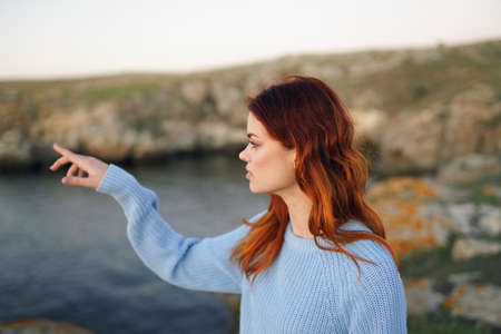 woman in blue sweater outdoors fresh air rocky mountains landscape recreationの写真素材