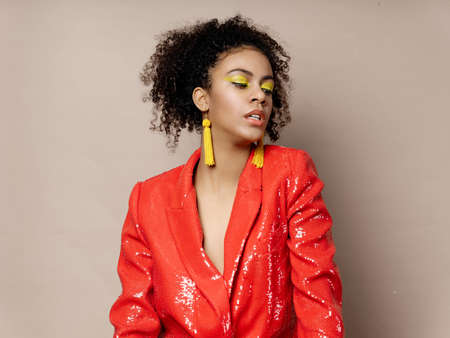 fashionable african woman with yellow earrings and red jacket disco party