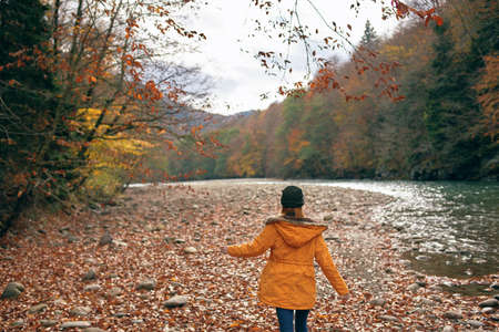 woman hiker near river mountains autumn travel