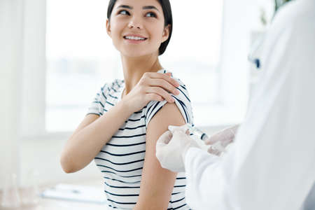 smiling woman in hospital making coronavirus vaccine