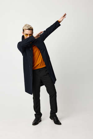 fashionable man in black coat gesturing with hands modern style full length