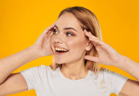 Happy woman delight emotions joy blonde on a yellow background gestures with her handsの写真素材