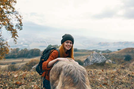 woman hiker in nature next to dog landscape travelの写真素材
