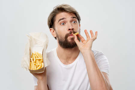 bearded man in white t-shirt french fries fast food diet