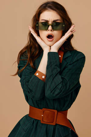 emotional woman holding hands on face sunglasses suit isolated background
