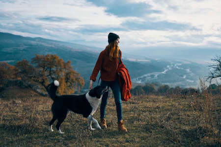 woman hiker dog walking nature mountains landscapeの写真素材