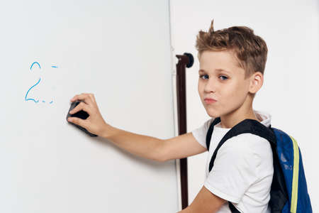 schoolboy with a backpack near the blackboard lesson task educationの写真素材