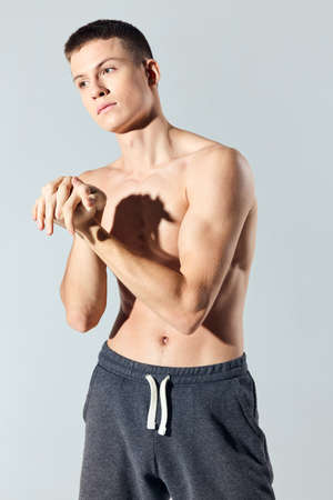 man with pumped up abs workout pants joined handsの写真素材