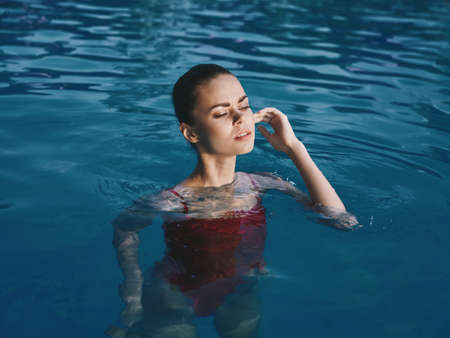 woman in swimsuit in the pool outdoors closed eyes luxury leisureの写真素材