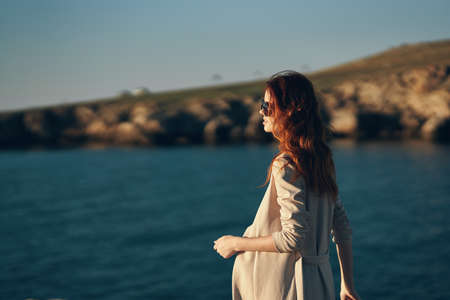 model in glasses woman walking on the beach near the sea in the garage side viewの写真素材