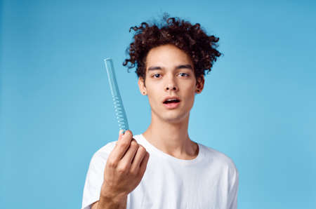 handsome guy with curly hair on a blue background portrait close-up tangled curlsの写真素材