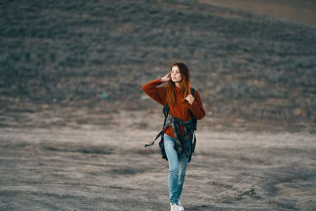 happy woman in red sweater with backpack on her back resting in natureの写真素材