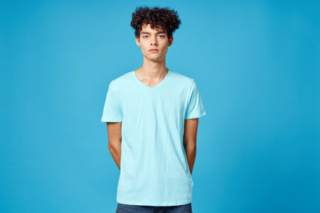 cute guy curly hair blue t-shirt isolated backgroundの写真素材
