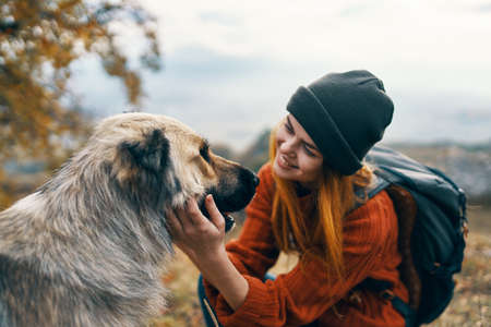 cheerful woman tourist petting a dog outdoors landscape vacationの写真素材