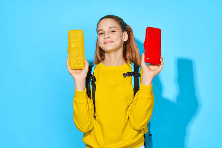school girl with backpack pencil case training blue backgroundの写真素材