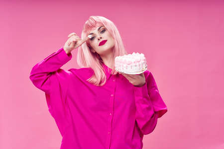 glamorous woman holding cake in hands of sweets enjoyment pink backgroundの写真素材