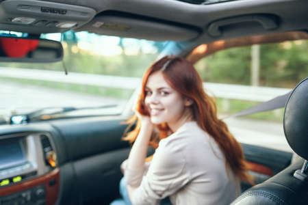 woman fellow traveler in a car salon in the front seat design open window natureの写真素材