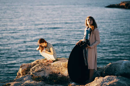 pretty woman in the summer in the mountains near the sea On a high stone