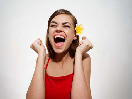 woman clenched her hands into a fist Delight emotions yellow flower in her hairの写真素材