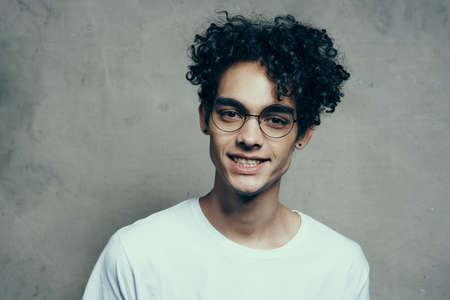 man with glasses curly hair white t-shirt studio emotion