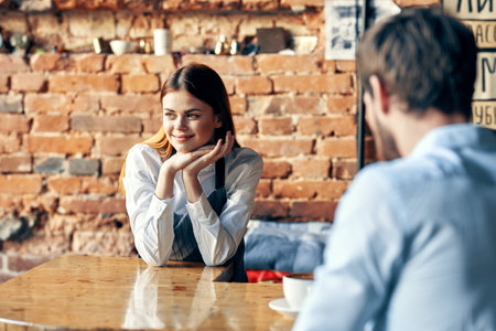 female waiter brings coffee to customer of service cafeの写真素材