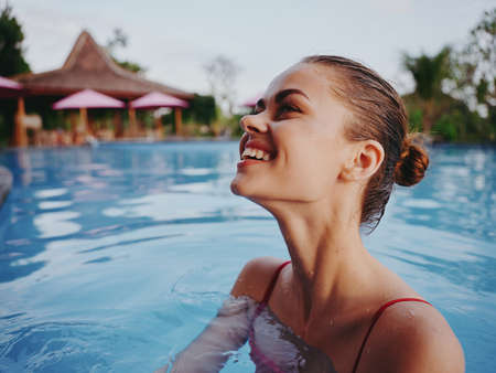happy woman with wet hair swim in the pool in nature