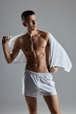 man naked torso in white shorts on the shoulders posing isolated backgroundの写真素材