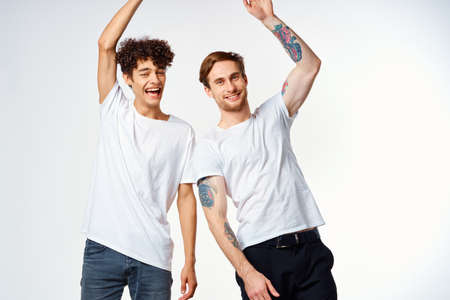 two men in white t-shirts are standing next to friendship emotionsの写真素材