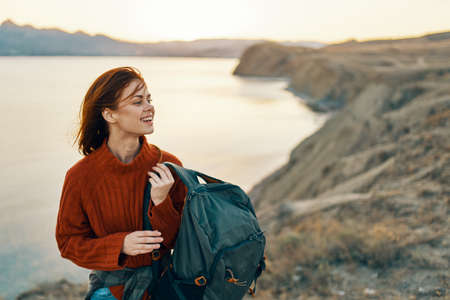happy woman tourist in a red sweater in the mountains in nature near the seaの写真素材