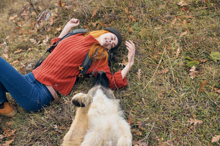 cheerful woman playing with dog nature travel friendship