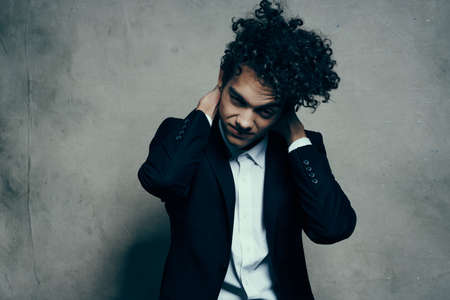 emotional man in classic suit gesturing with his hands indoors with fabric backgroundの写真素材