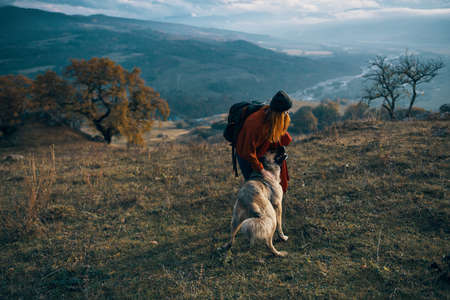 women hikers next to dog walk mountains autumn