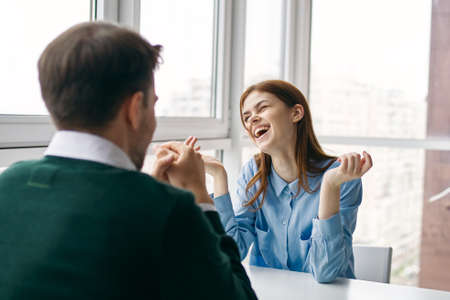 man and woman sitting at the table work colleagues communication funの写真素材