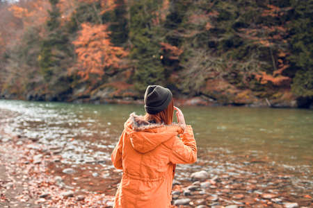 cheerful woman Tourist in a jacket Autumn forest river natureの写真素材