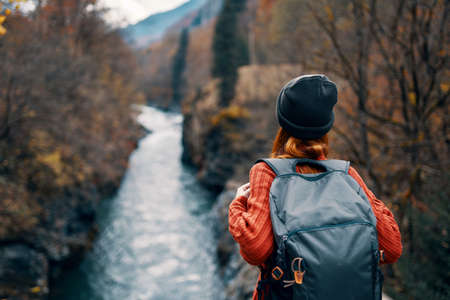 woman with backpack admires the river in the mountains nature travelの写真素材