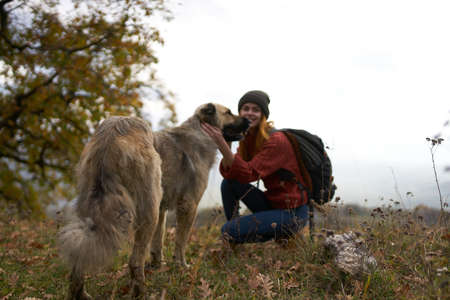 woman tourist playing dog nature landscape friendshipの写真素材