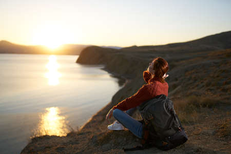 pretty woman tourist with backpack admiring the landscape sunset vacation