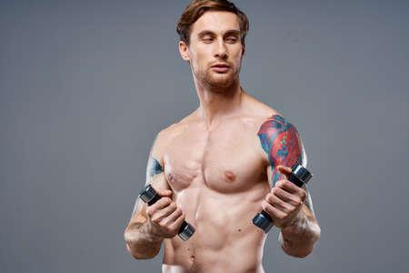 sexy athlete with pumped up arm muscles and health vitamins dumbbells modelの写真素材