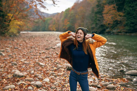 joyful woman in nature Autumn forest river freedom
