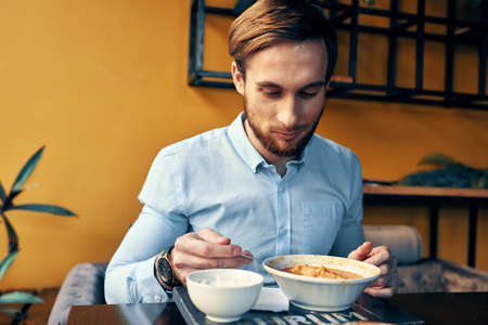 business man in blue shirt having lunch at a cafe tableの写真素材
