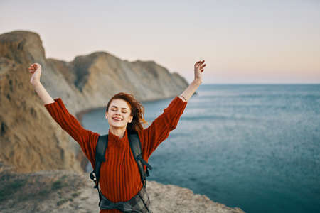 traveler in the mountains near the sea in nature top view sweater backpackの写真素材