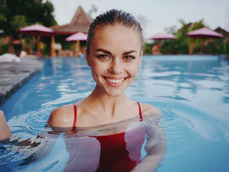 cheerful smiling woman in swimsuit in the pool island natureの写真素材