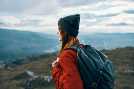 woman jacket hats looking at the mountain in the distance blue sky clouds Model backpackの写真素材