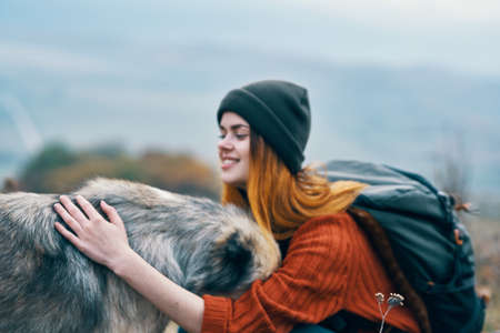 woman tourist hugs dog nature travel friendshipの写真素材